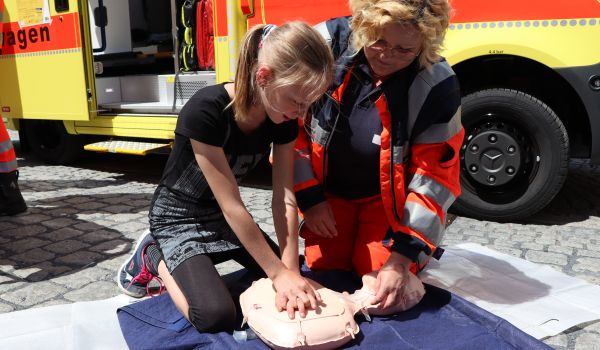 Ein Kind übt die Herzdruckmassage.