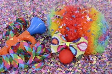 Ein Clownkostüm liegt auf Konfetti.