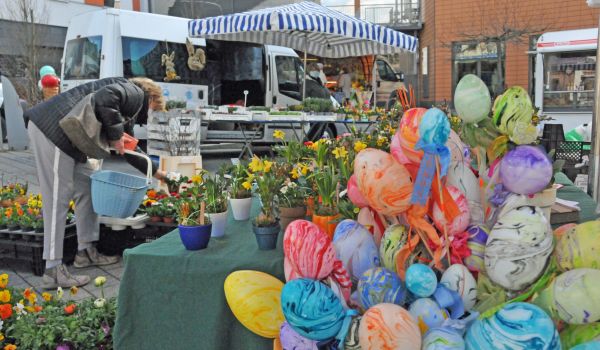 Frühblüher und Osterdeko werden auf einem Markt angeboten.