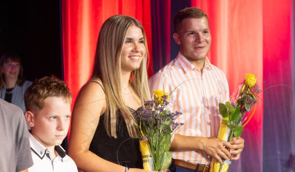 Menschen mit Päsenten auf einer Bühne.