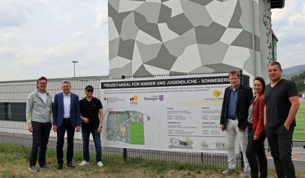 Sechs Personen stehen neben einem Schild mit der Aufschrift: Freizeitareal für Kinder und Jugendliche Sonneberg.