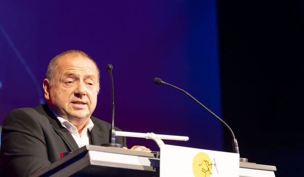 Ein Mann im Anzug steht am Rednerpult.