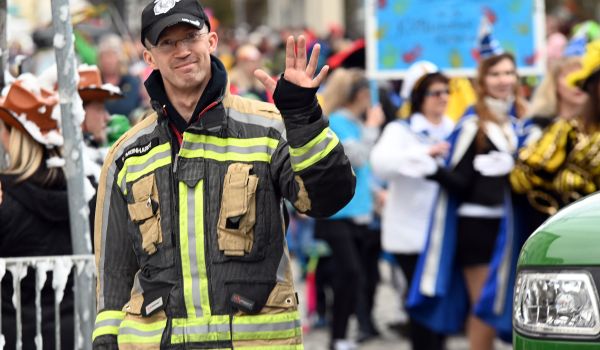 Ein Mann im Feuerwehrkostüm läuft beim Faschingsumzug mit.