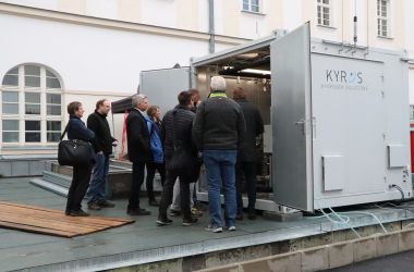 Interessierte Gäste schauen in einen Container.