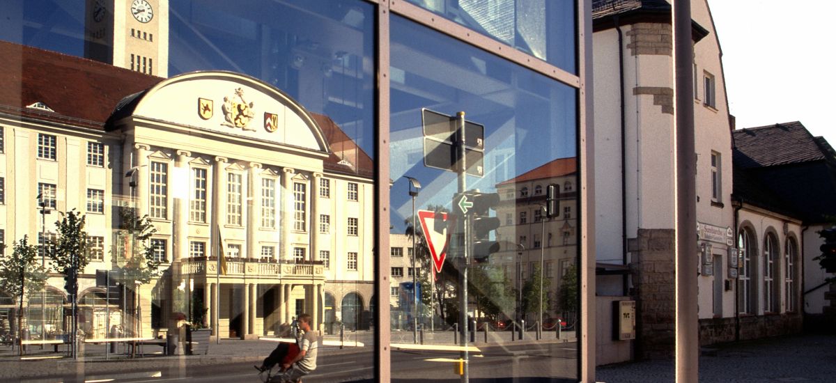 In einer Scheibe spiegelt sich das Rathaus des Stadt Sonneberg.