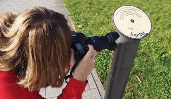 Eine Frau fotografiert eine Metallstange.