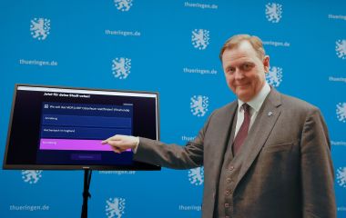 Ein Mann steht vor einem Display und tippt auf Sonneberg.