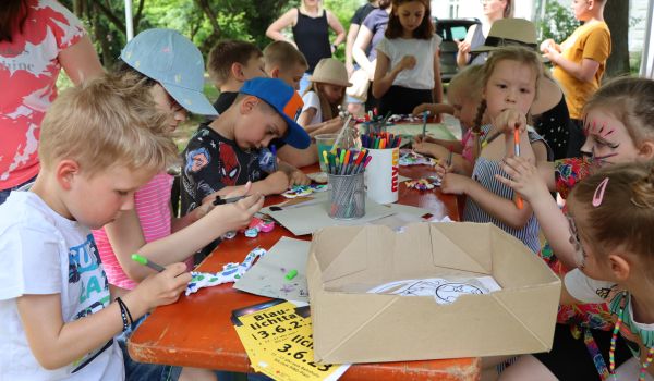 Kinder sitzen an einem Tisch und basteln.