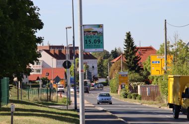 Ein Plakat hängt an einer Straßenlaterne.