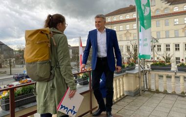 Eine Frau und ein Mann stehen auf einem Balkon.