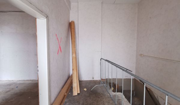 Eine Baustelle in einem Gebäude. Auf dem Boden liegen Bretter.