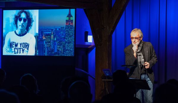 Ein Mann steht auf einer Bühne und hält ein Mikrofon in der Hand.