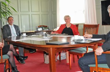 Vier Personen sitzen an einem Tisch.