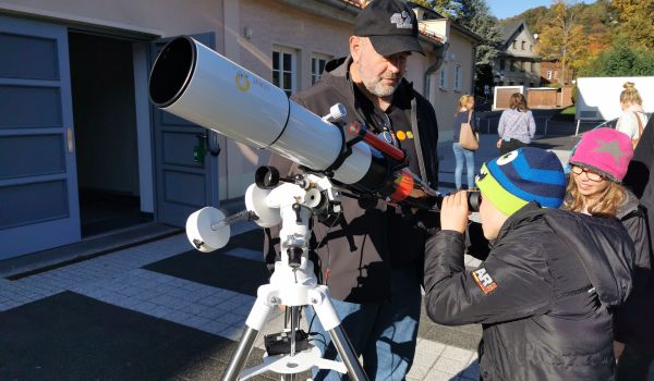 Kinder schauen durch ein Teleskop.