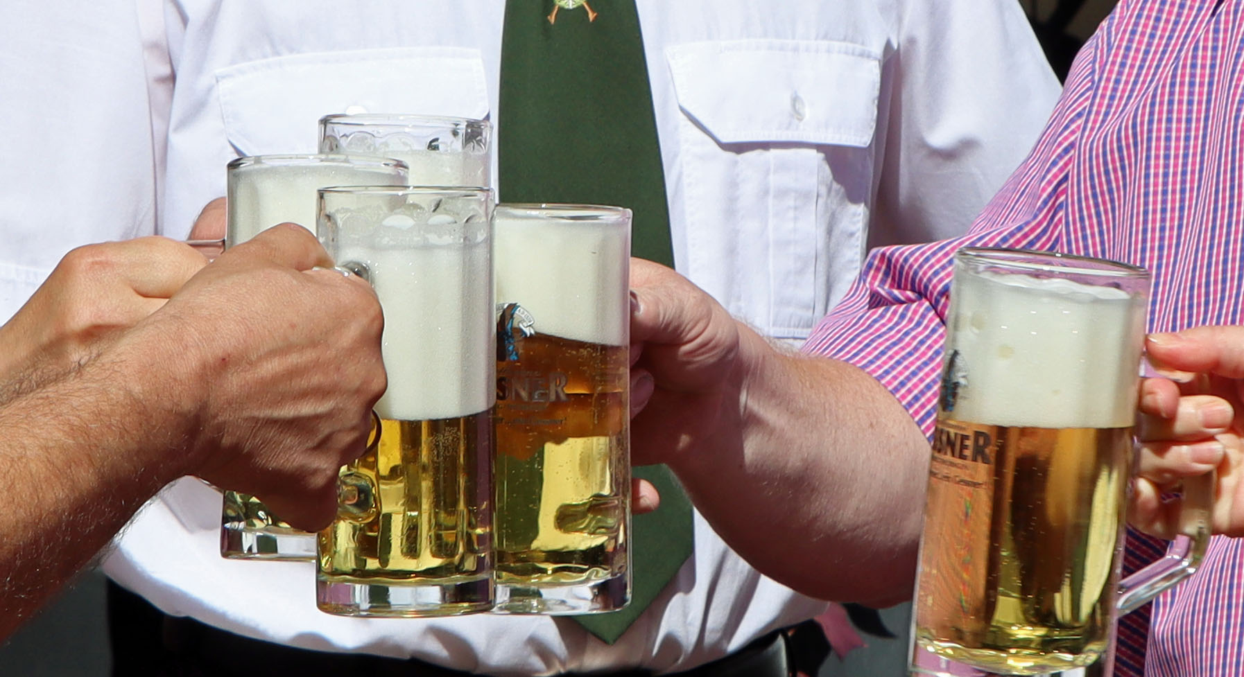 Fünf Menschen halten Biergläser in die Kamera.