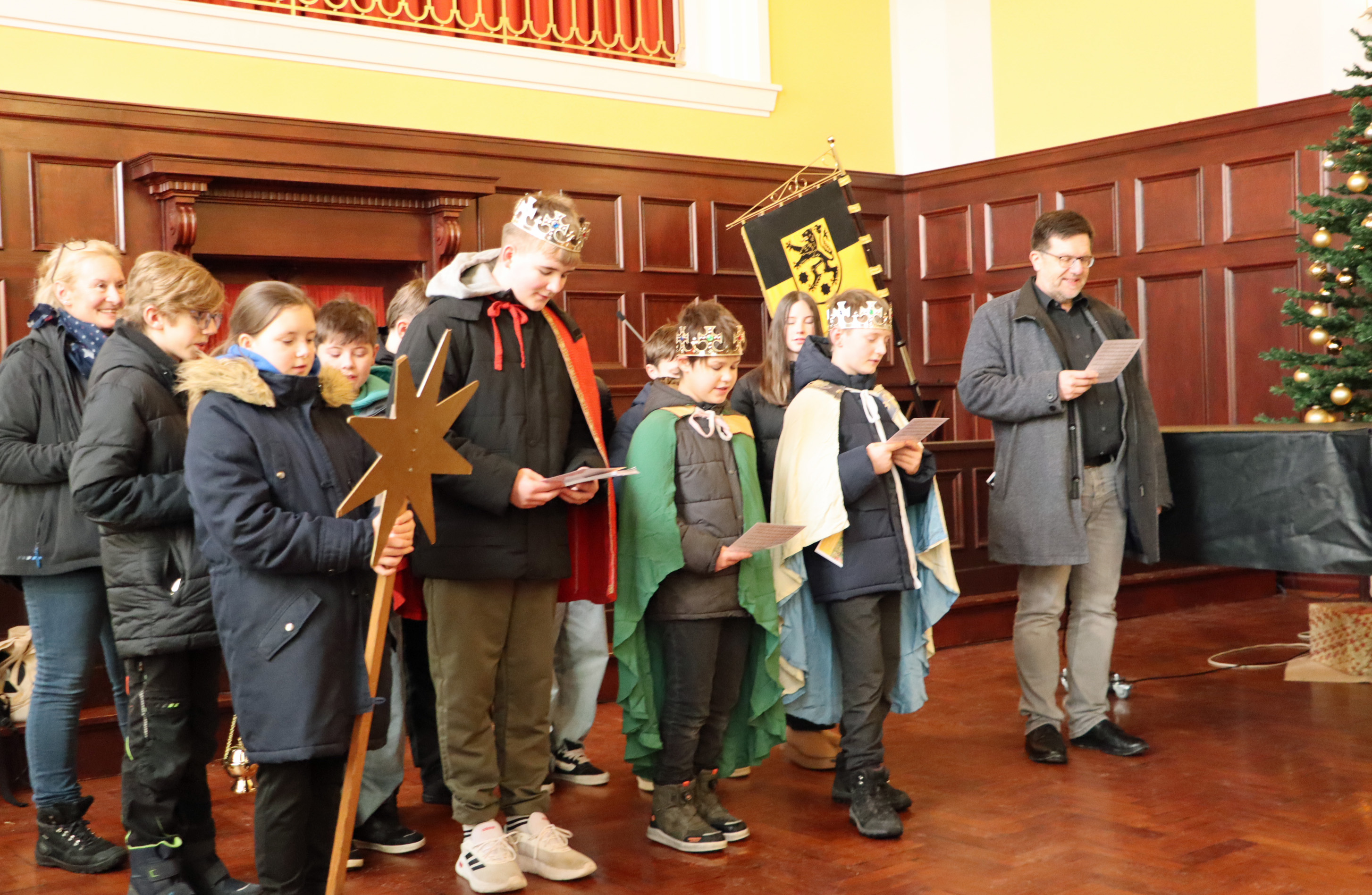 Jungen und Mädchen singen als die Heiligen Drei Könige verkleidet im Sonneberger Rathaussaal.