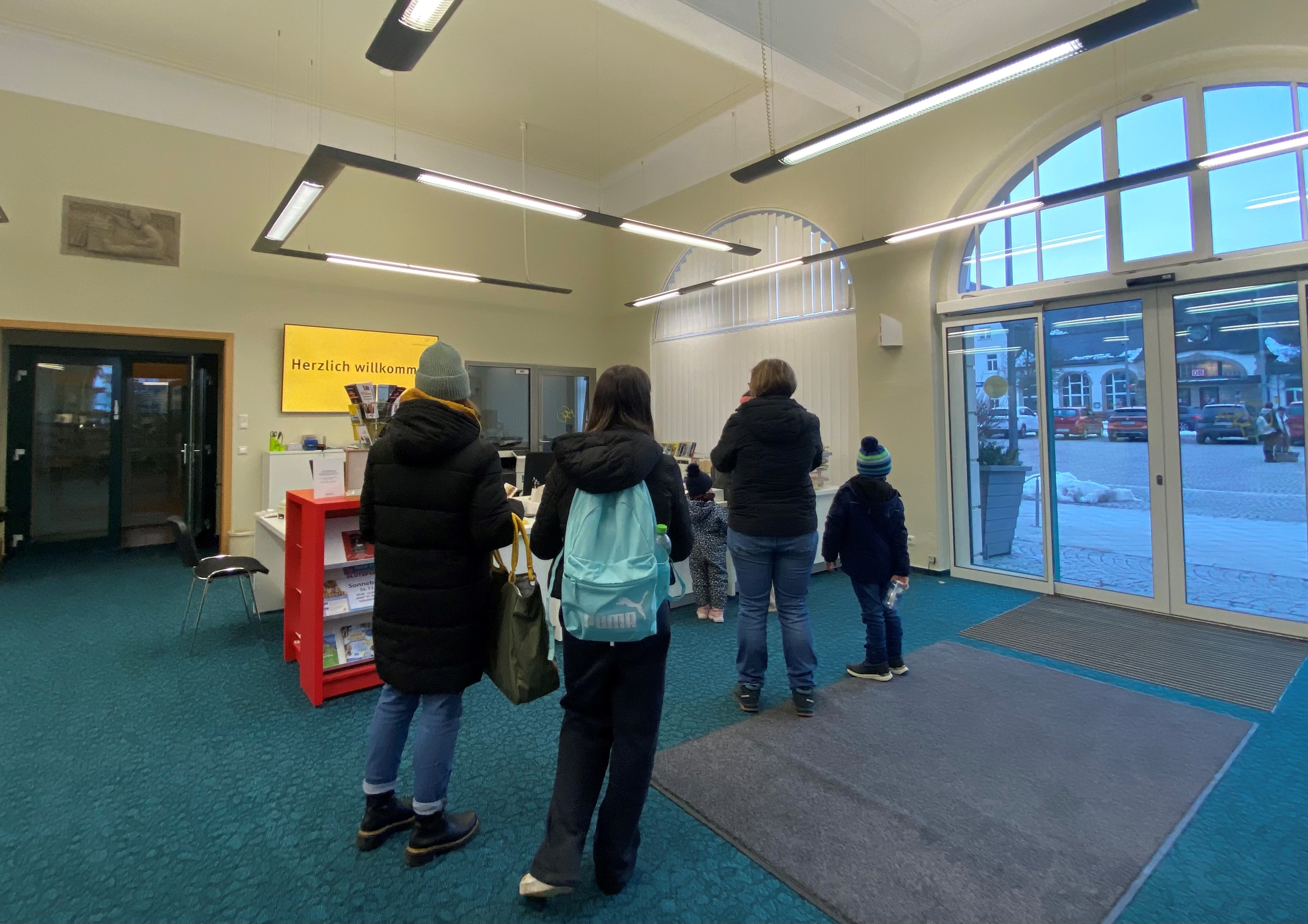 Am Bibliotheksschalter steht einen Menschenschlange.