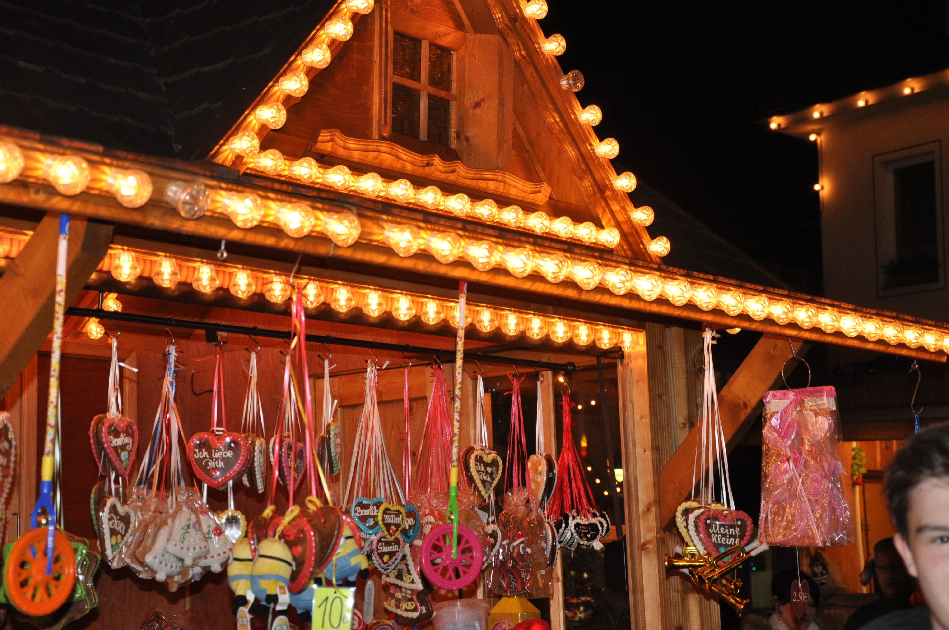 Ein beleuchteter Weihnachtsmarktstand mit Süßigkeiten.